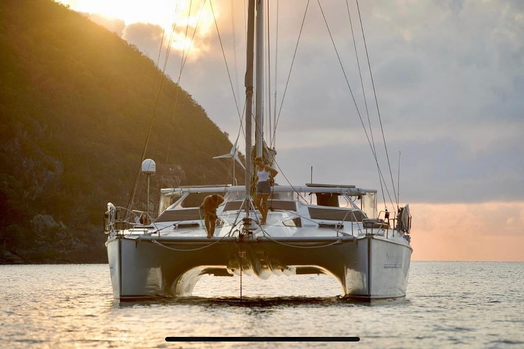 Excelsior, the Privilege 14.7 catamaran, anchored at sunset with mountains behind